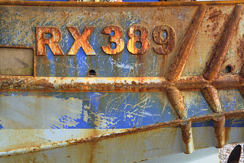 The rusted hull of RX389 fishing boat on Hastings beach photographed by pop artist Trevor Heath